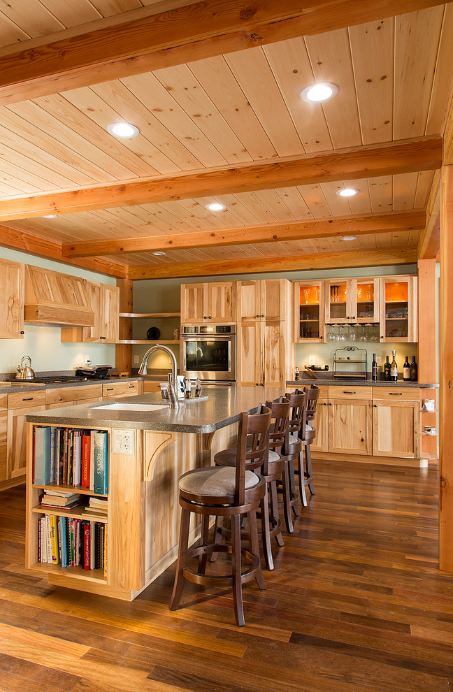Inspiration for a large rustic u-shaped dark wood floor eat-in kitchen remodel in Burlington with an undermount sink, shaker cabinets, medium tone wood cabinets, solid surface countertops, an island and stainless steel appliances