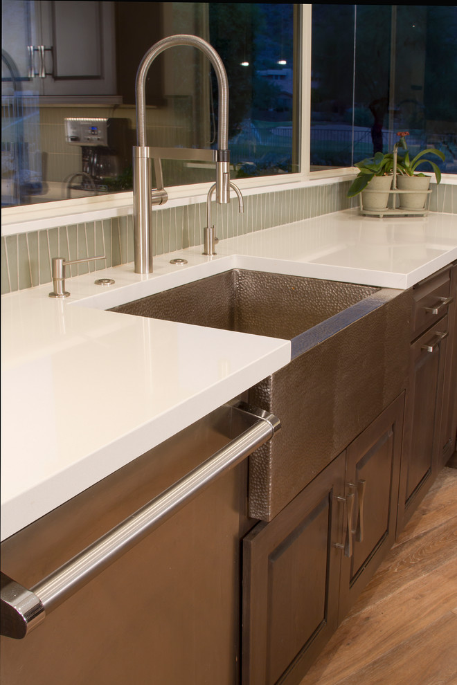 Inspiration for a mid-sized transitional l-shaped light wood floor and brown floor eat-in kitchen remodel in Phoenix with a farmhouse sink, shaker cabinets, dark wood cabinets, quartzite countertops, beige backsplash, glass sheet backsplash, stainless steel appliances, an island and white countertops