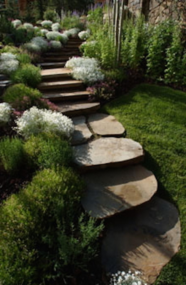 Photo of a huge rustic full sun backyard stone water fountain landscape in Denver.