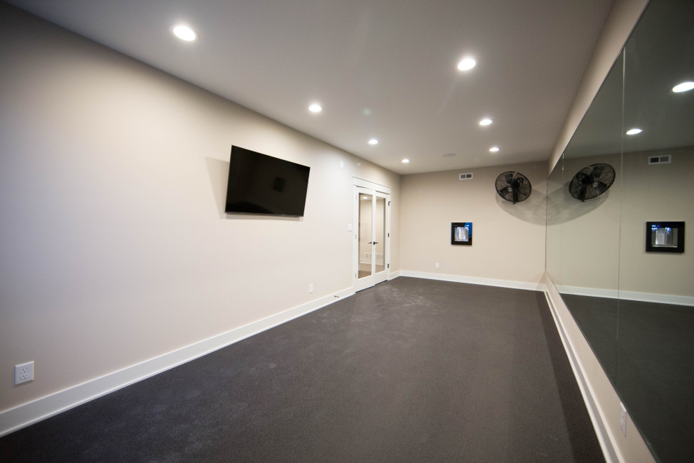 This is an example of a large contemporary multipurpose gym in Indianapolis with beige walls and black floor.