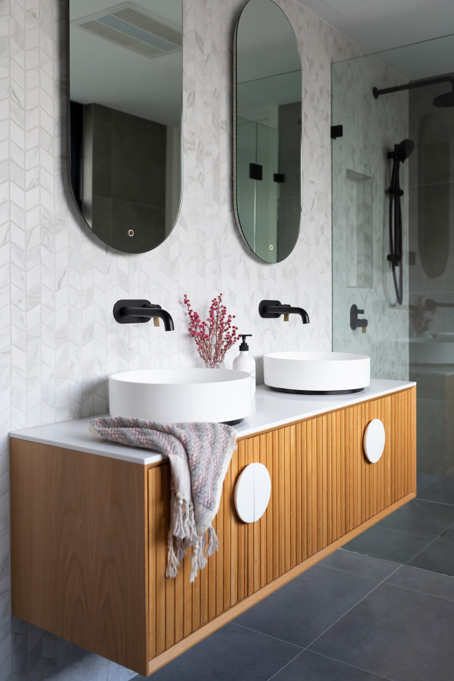 Inspiration för mellanstora moderna grått badrum, med skåp i mörkt trä, en vägghängd toalettstol, svart och vit kakel, porslinskakel, klinkergolv i porslin, ett fristående handfat, bänkskiva i kvarts, grått golv och släta luckor