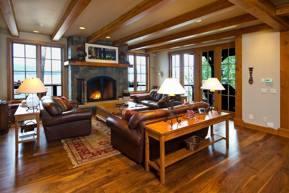 Inspiration for an arts and crafts open concept living room in Boise with white walls, medium hardwood floors, a standard fireplace, a stone fireplace surround and no tv.