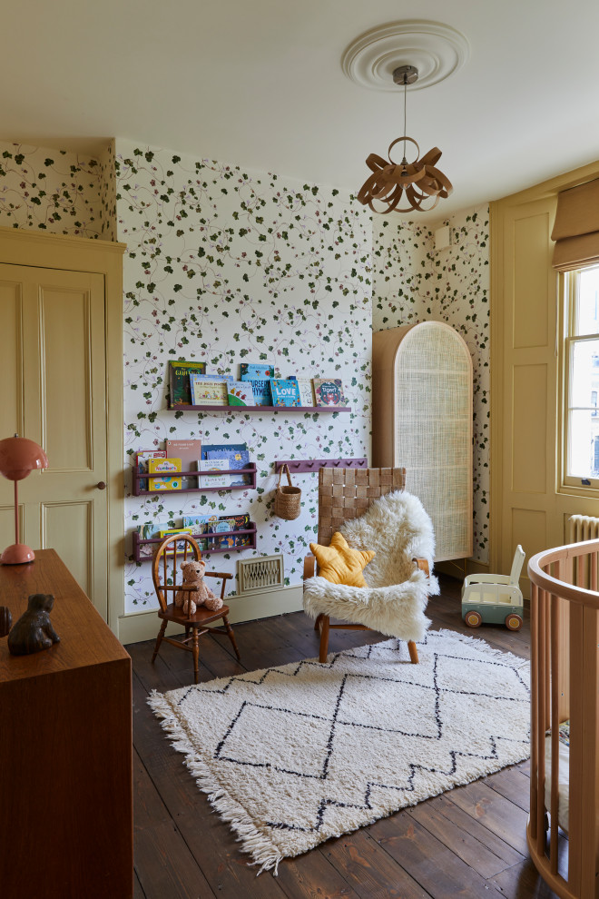 Imagen de habitación de bebé neutra clásica renovada de tamaño medio con suelo de madera oscura, suelo marrón, papel pintado y paredes multicolor
