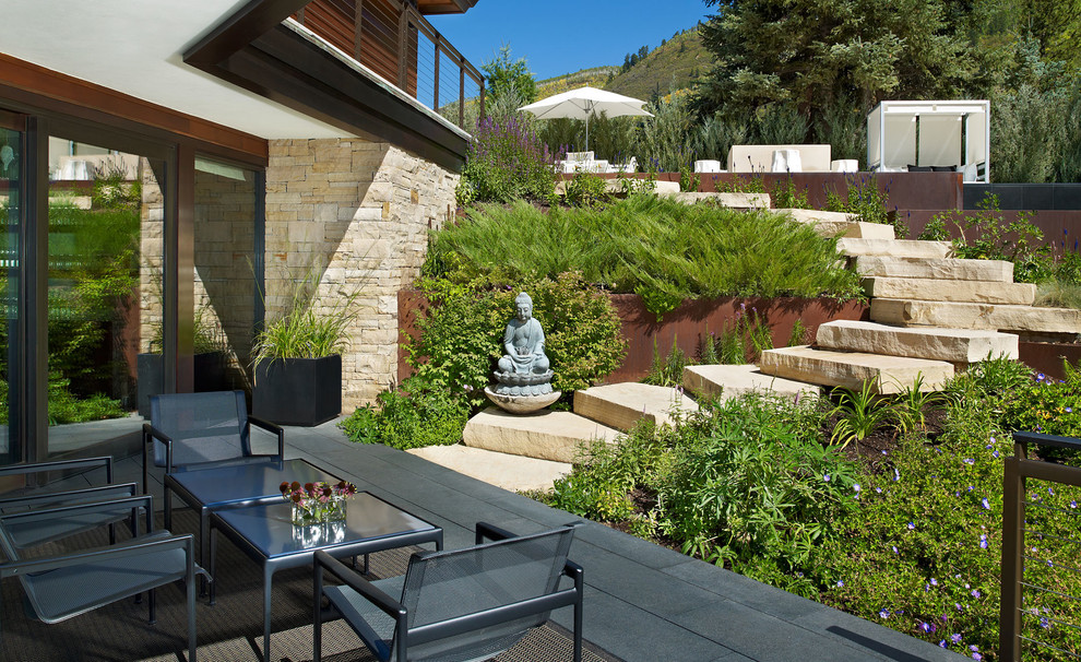 Inspiration for a contemporary backyard patio in Denver with a roof extension.
