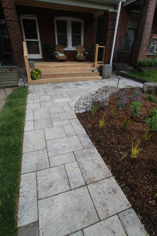 Inspiration for a small contemporary front yard verandah in Toronto with concrete pavers.