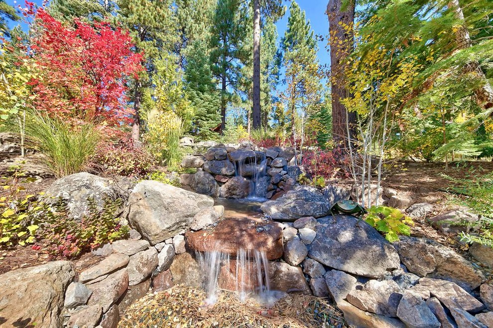 Design ideas for a large transitional drought-tolerant and partial sun backyard concrete paver water fountain landscape for summer.
