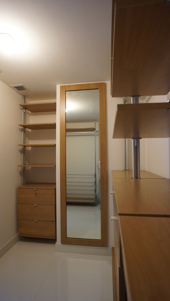 This is an example of a mid-sized contemporary gender-neutral walk-in wardrobe in Miami with open cabinets, medium wood cabinets and porcelain floors.