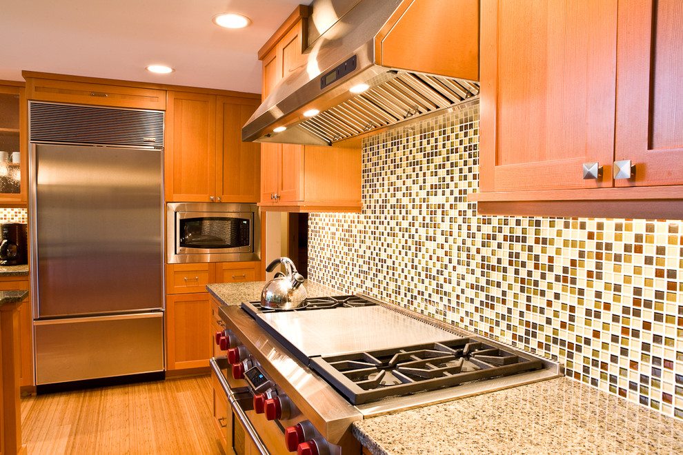 This is an example of a contemporary kitchen in Seattle with stainless steel appliances, shaker cabinets, medium wood cabinets, multi-coloured splashback and mosaic tile splashback.