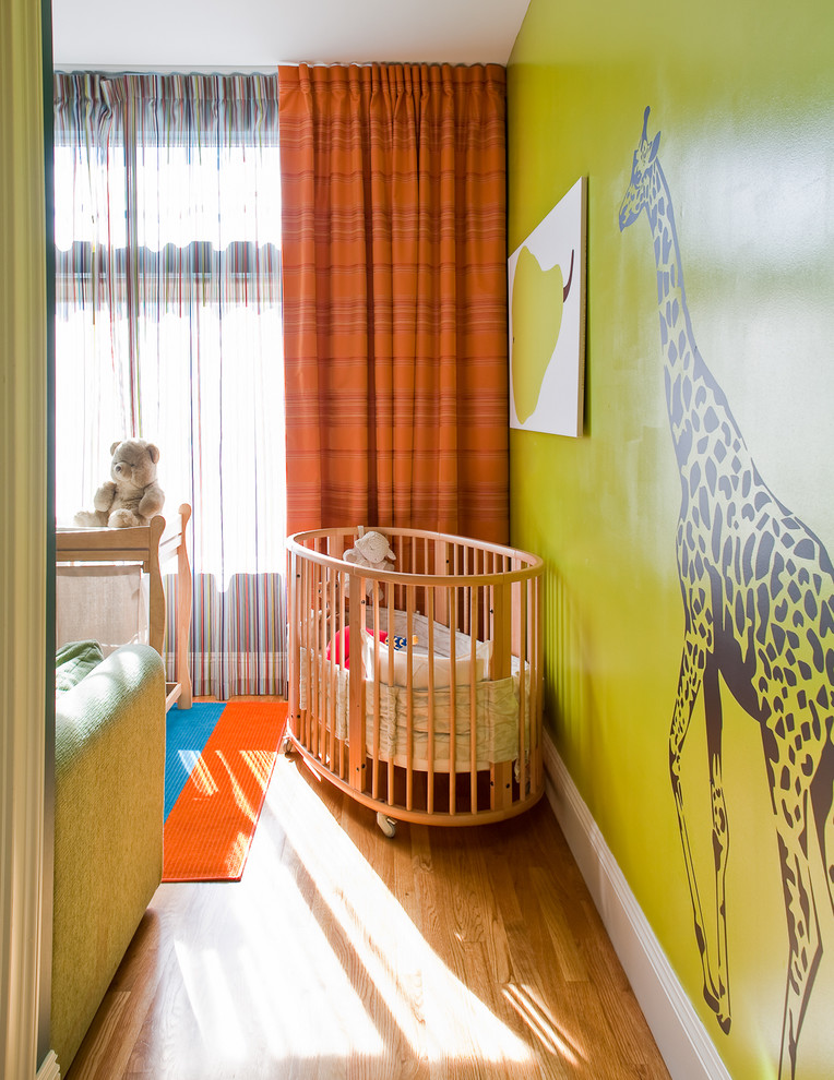 Photo of a contemporary gender-neutral nursery in San Francisco with green walls and medium hardwood floors.