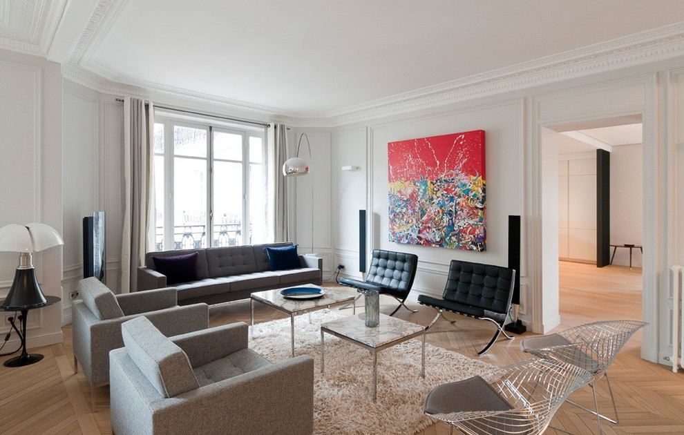Large contemporary formal enclosed living room in Paris with white walls, light hardwood floors, no fireplace and no tv.
