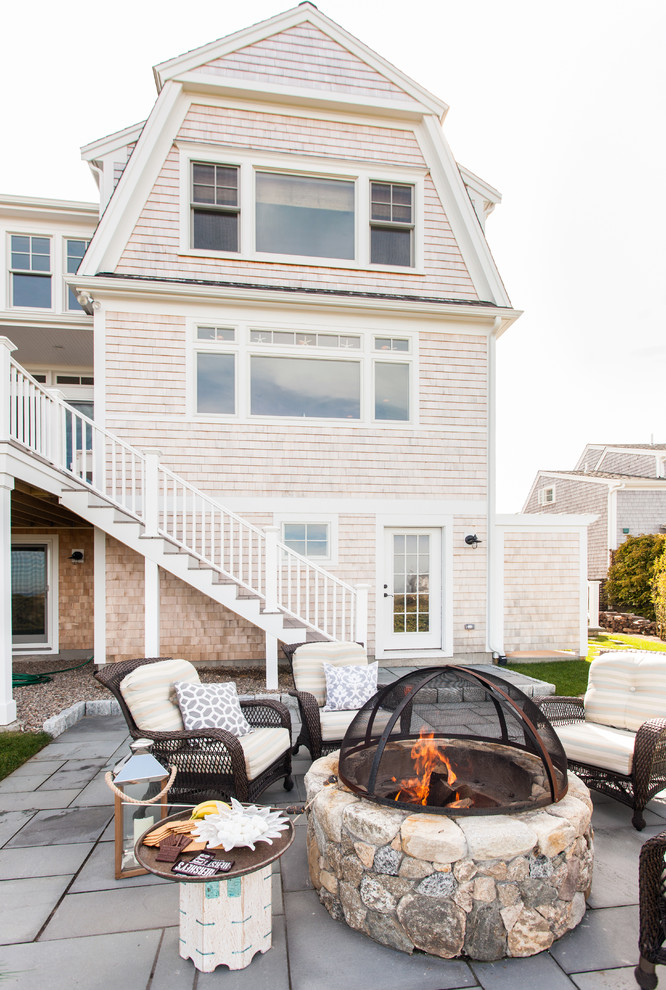 Design ideas for a mid-sized beach style backyard patio in Boston with a fire feature, natural stone pavers and no cover.