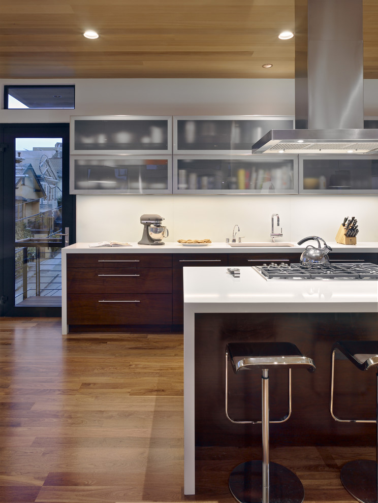 This is an example of a contemporary kitchen in San Francisco with glass-front cabinets and dark wood cabinets.