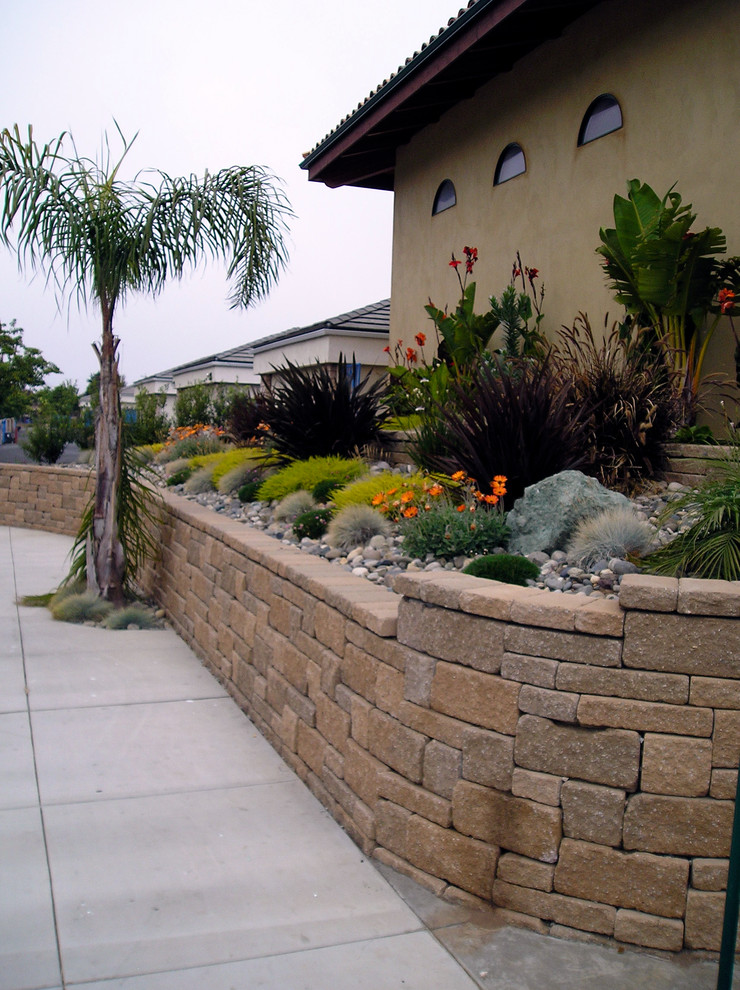 Inspiration for a mid-sized traditional front yard garden in San Luis Obispo with a retaining wall and natural stone pavers.