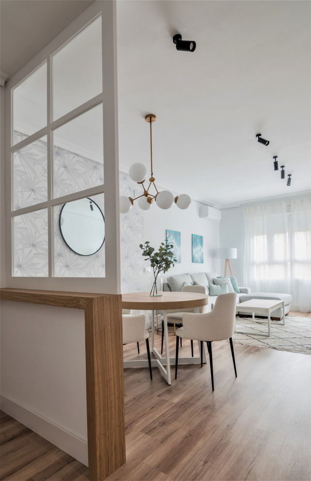 Свежая идея для дизайна: маленькая открытая, серо-белая гостиная комната в скандинавском стиле с белыми стенами, полом из ламината, коричневым полом, обоями на стенах и красивыми шторами для на участке и в саду - отличное фото интерьера