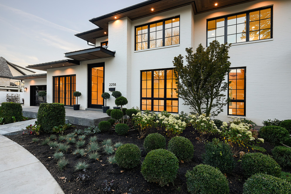 Contemporary two-storey brick white house exterior in Salt Lake City with a flat roof and a shingle roof.