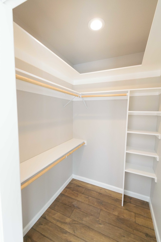 Mid-sized transitional gender-neutral walk-in wardrobe in San Francisco with white cabinets, laminate floors and brown floor.