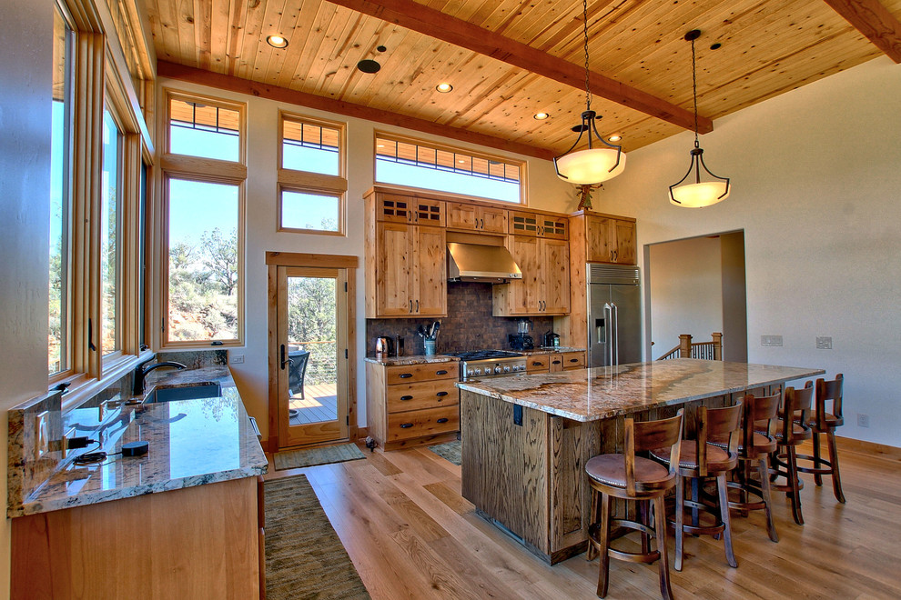 Open concept kitchen - mid-sized craftsman l-shaped light wood floor and beige floor open concept kitchen idea with an undermount sink, shaker cabinets, light wood cabinets, granite countertops, metallic backsplash, metal backsplash, stainless steel appliances, an island and beige countertops