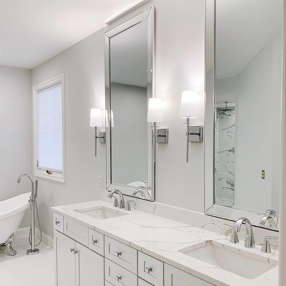 This is an example of a mid-sized modern master bathroom in Detroit with shaker cabinets, white cabinets, a freestanding tub, an open shower, a one-piece toilet, white tile, marble, grey walls, marble floors, an undermount sink, quartzite benchtops, white floor, a hinged shower door and white benchtops.