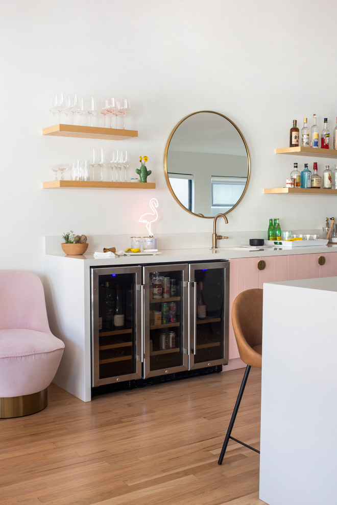 This is an example of a contemporary home bar in Los Angeles with white benchtop.
