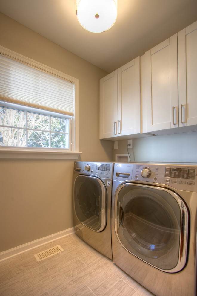 Design ideas for a small transitional single-wall utility room in Richmond with recessed-panel cabinets, white cabinets, grey walls, ceramic floors and a side-by-side washer and dryer.