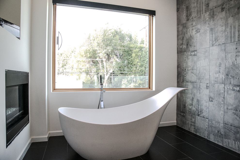 This is an example of a large modern master bathroom in Los Angeles with flat-panel cabinets, white cabinets, a freestanding tub, a corner shower, white walls, porcelain floors, an integrated sink, quartzite benchtops, black floor, a hinged shower door and white benchtops.