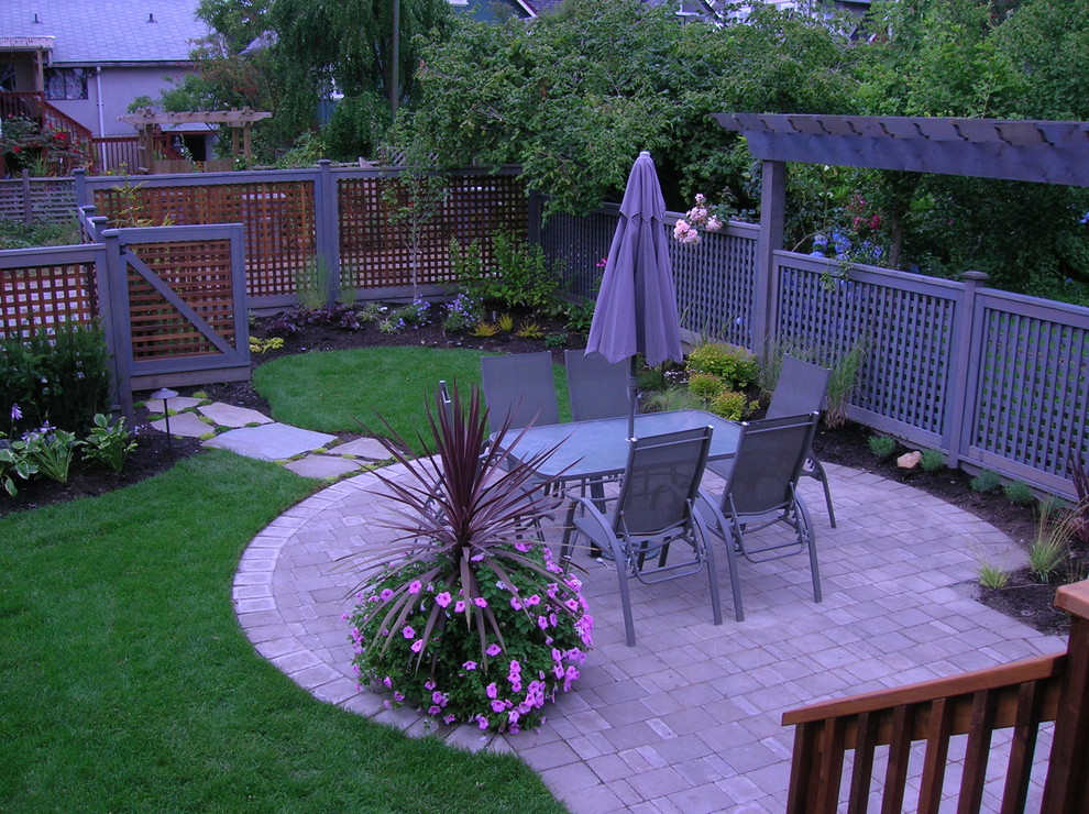 Mid-sized traditional backyard patio in Vancouver with concrete pavers and a pergola.