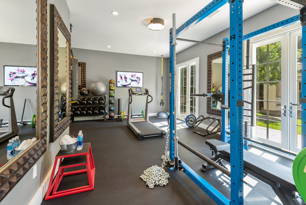 Large contemporary multipurpose gym in Los Angeles with grey walls, dark hardwood floors and brown floor.