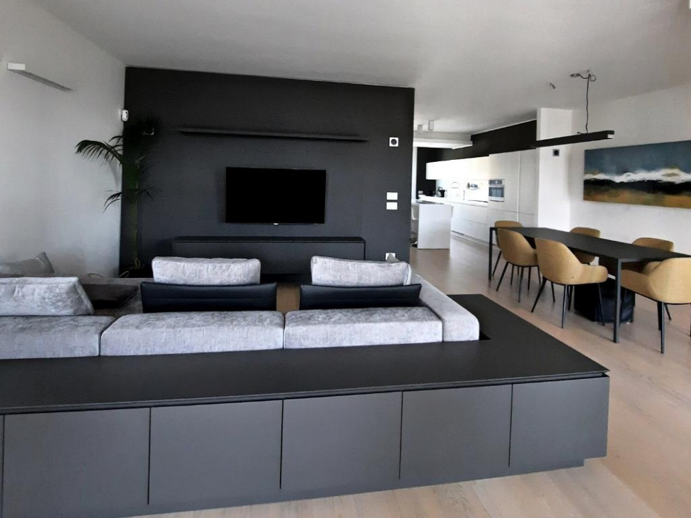 Bild på ett mellanstort funkis allrum med öppen planlösning, med en hemmabar, grå väggar, ljust trägolv, en väggmonterad TV och beiget golv