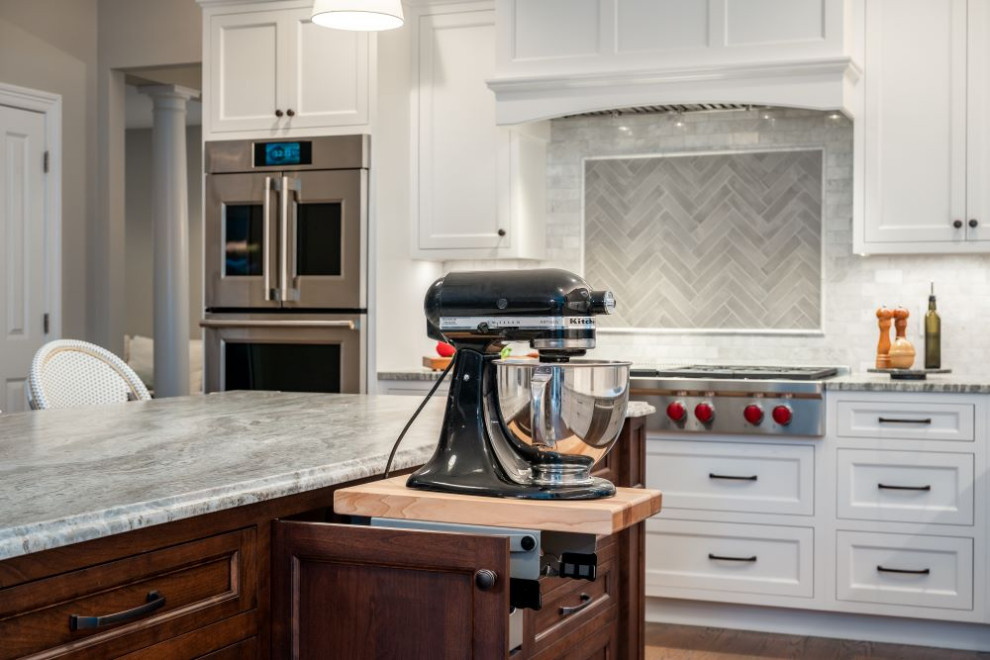 Example of a large transitional l-shaped eat-in kitchen design with stainless steel appliances, an island and gray countertops