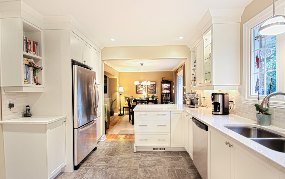 Inspiration for a mid-sized transitional l-shaped separate kitchen in Ottawa with a double-bowl sink, recessed-panel cabinets, white cabinets, granite benchtops, white splashback, stone tile splashback, stainless steel appliances, a peninsula, marble floors and grey floor.