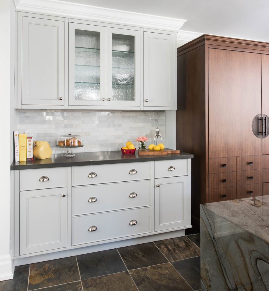 Eat-in kitchen - mid-sized transitional l-shaped slate floor and brown floor eat-in kitchen idea in Toronto with an undermount sink, white cabinets, marble countertops, white backsplash, brick backsplash, stainless steel appliances, an island and multicolored countertops