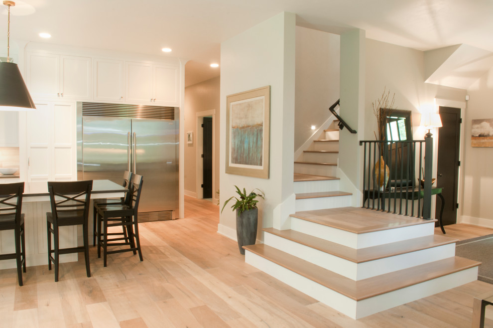 Eat-in kitchen - mid-sized transitional l-shaped light wood floor and beige floor eat-in kitchen idea with an undermount sink, shaker cabinets, white cabinets, solid surface countertops, multicolored backsplash, porcelain backsplash, stainless steel appliances and an island