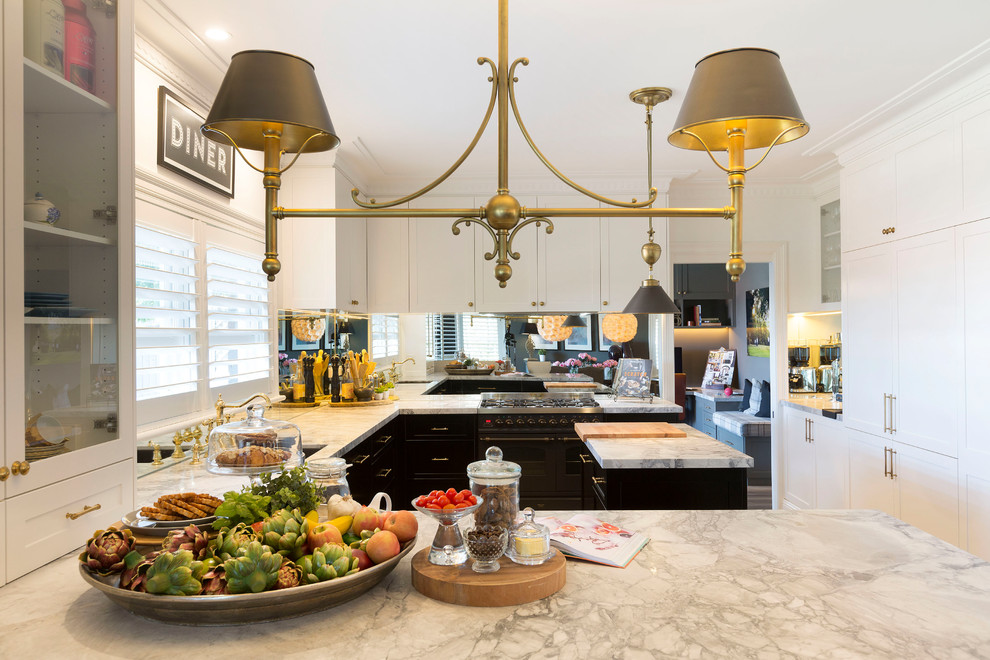 This is an example of a mid-sized transitional u-shaped kitchen in Sydney with a single-bowl sink, shaker cabinets, marble benchtops, metallic splashback, mirror splashback and with island.
