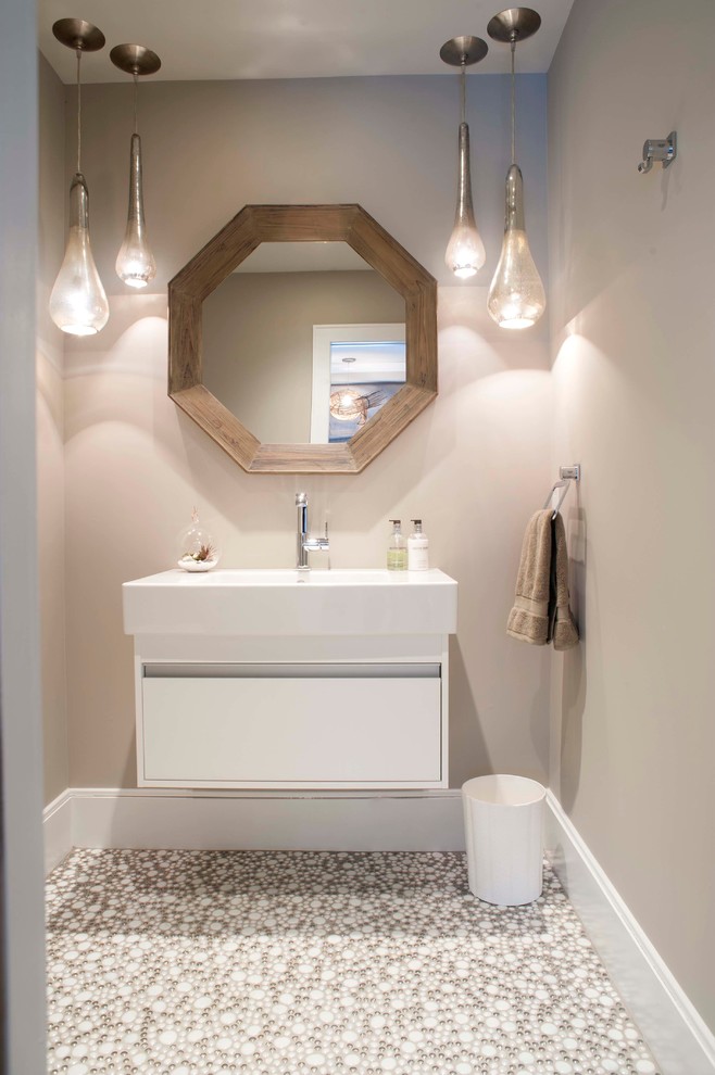 This is an example of a mid-sized beach style powder room in Other with an integrated sink, flat-panel cabinets, white tile and grey walls.