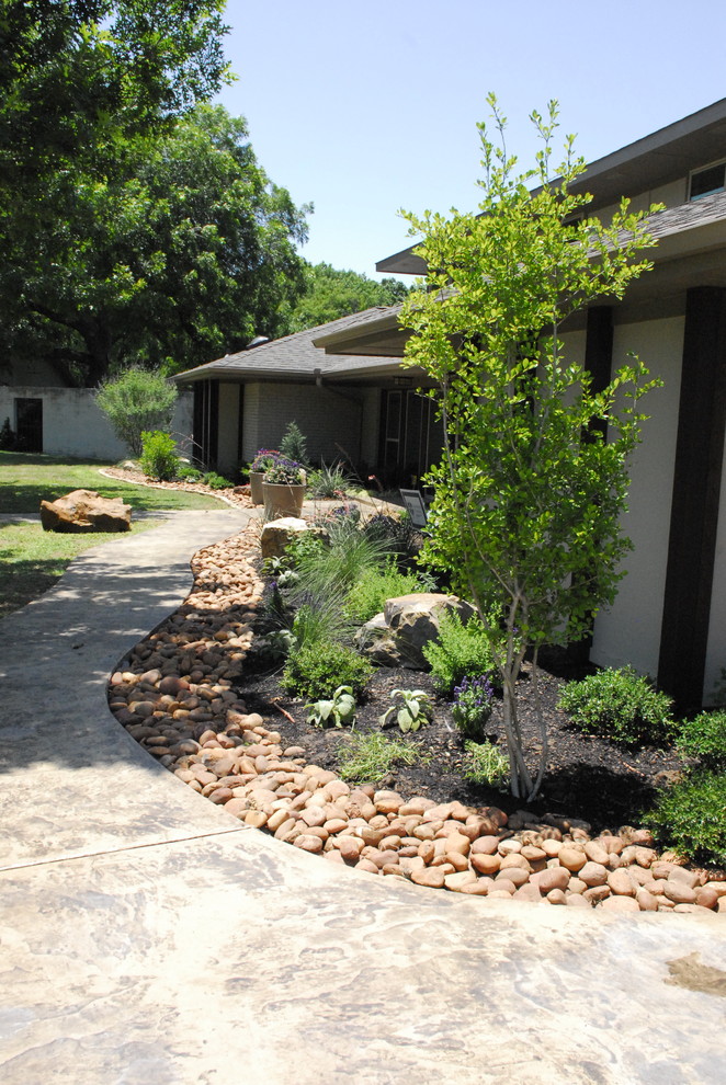 Mid-sized midcentury front yard full sun xeriscape in Dallas with a garden path and natural stone pavers for spring.