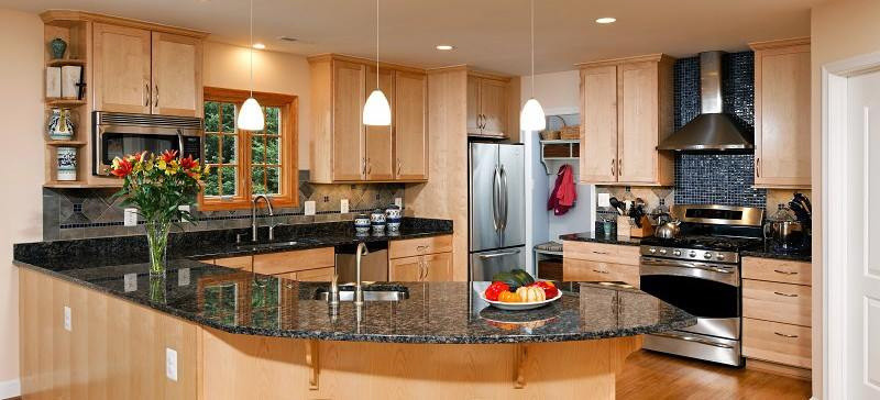 Enclosed kitchen - large transitional l-shaped light wood floor and brown floor enclosed kitchen idea with an undermount sink, shaker cabinets, light wood cabinets, granite countertops, black backsplash, mosaic tile backsplash, stainless steel appliances, a peninsula and black countertops