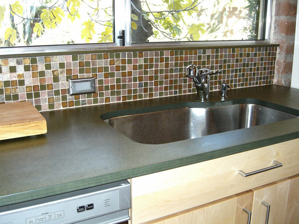 Transitional kitchen photo in Phoenix with an undermount sink, flat-panel cabinets, light wood cabinets, solid surface countertops, multicolored backsplash, mosaic tile backsplash and stainless steel appliances