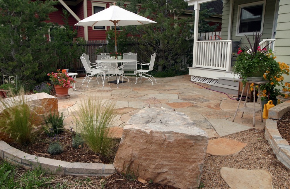 Inspiration for a mid-sized transitional backyard patio in Denver with a vegetable garden and natural stone pavers.