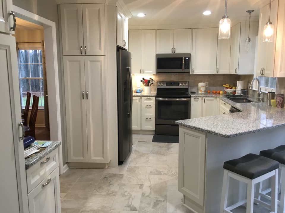 Enclosed kitchen - mid-sized transitional u-shaped porcelain tile and multicolored floor enclosed kitchen idea with an undermount sink, recessed-panel cabinets, white cabinets, granite countertops, beige backsplash, porcelain backsplash, black appliances, a peninsula and multicolored countertops