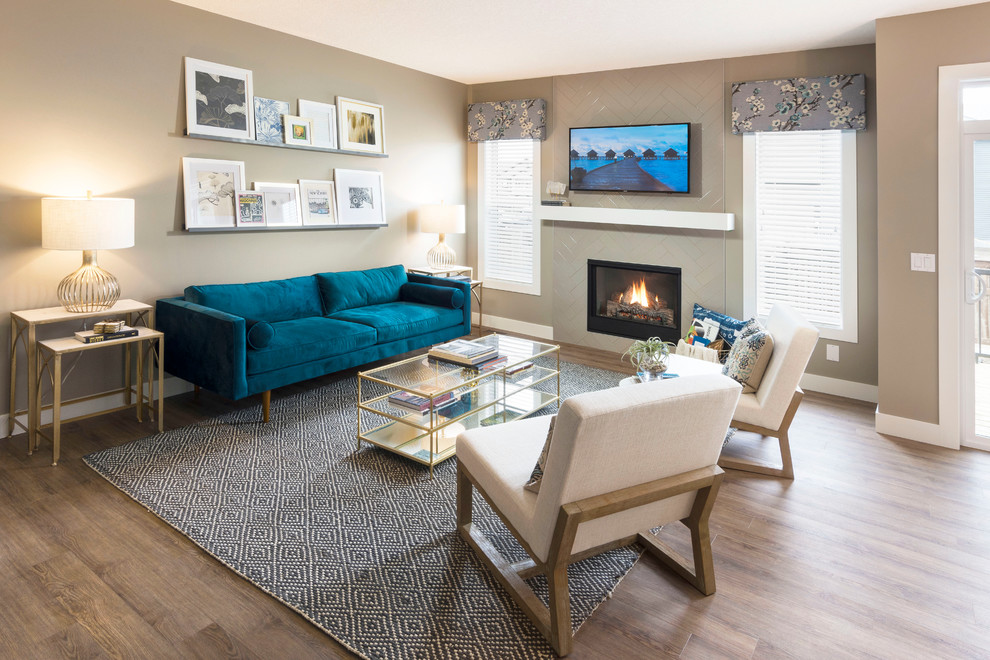 Small midcentury formal open concept living room in Calgary with brown walls, medium hardwood floors, a standard fireplace, a tile fireplace surround and a wall-mounted tv.