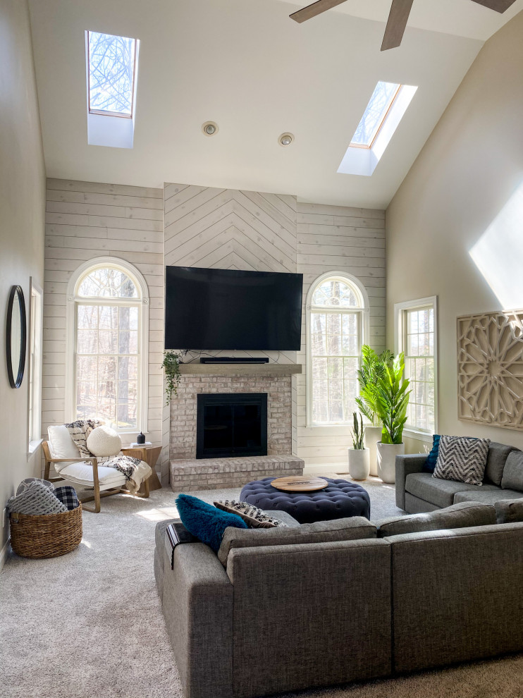 Design ideas for a large farmhouse open plan living room feature wall in New York with beige walls, carpet, a standard fireplace, a brick fireplace surround, a wall mounted tv, beige floors, a vaulted ceiling and tongue and groove walls.
