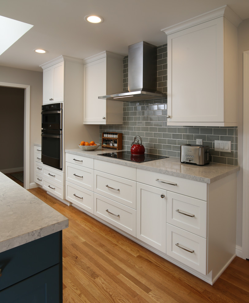 Idéer för att renovera ett stort funkis grå grått kök, med en undermonterad diskho, skåp i shakerstil, vita skåp, bänkskiva i kvarts, grått stänkskydd, stänkskydd i keramik, rostfria vitvaror, mellanmörkt trägolv, en köksö och brunt golv