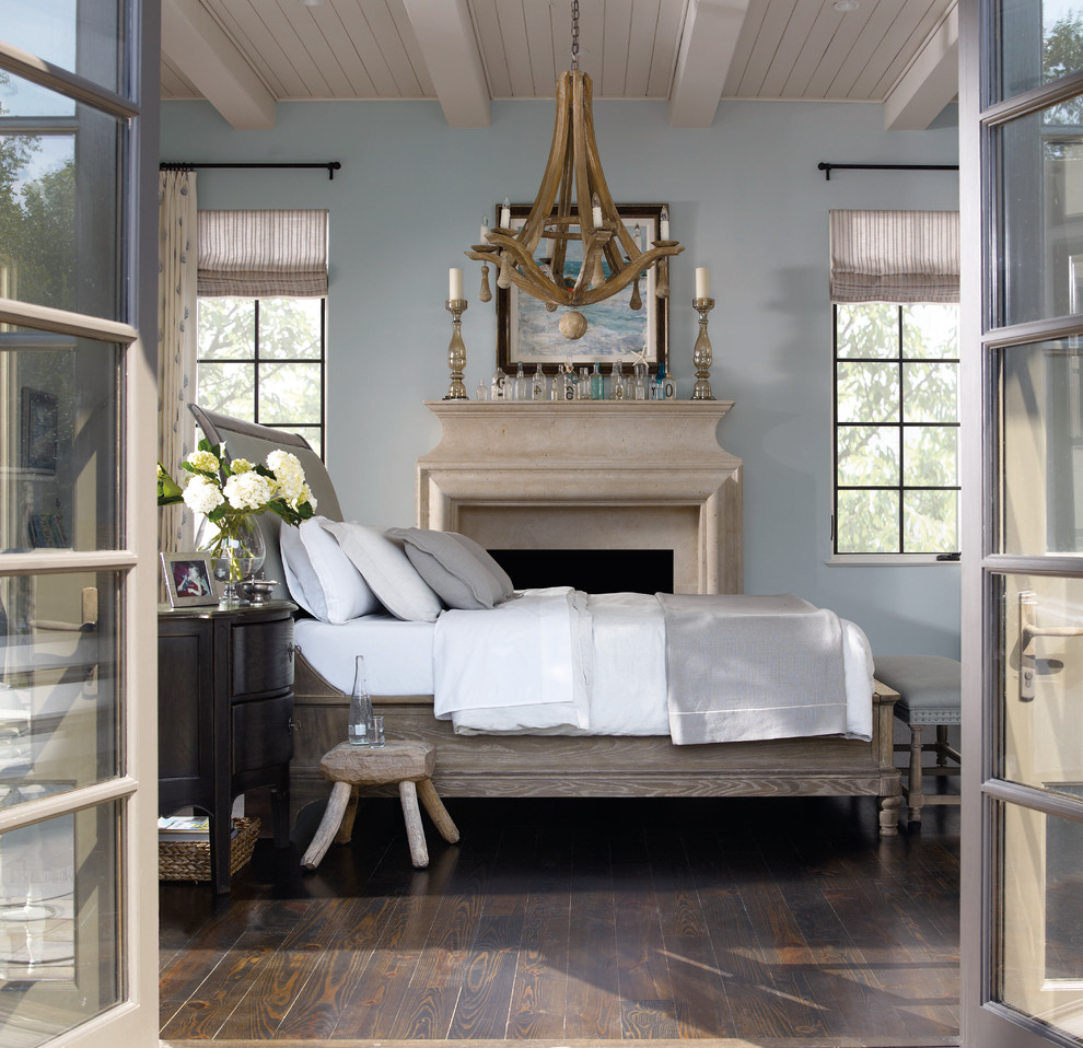 Design ideas for a large contemporary master bedroom in Philadelphia with blue walls, dark hardwood floors, a standard fireplace, a stone fireplace surround and brown floor.