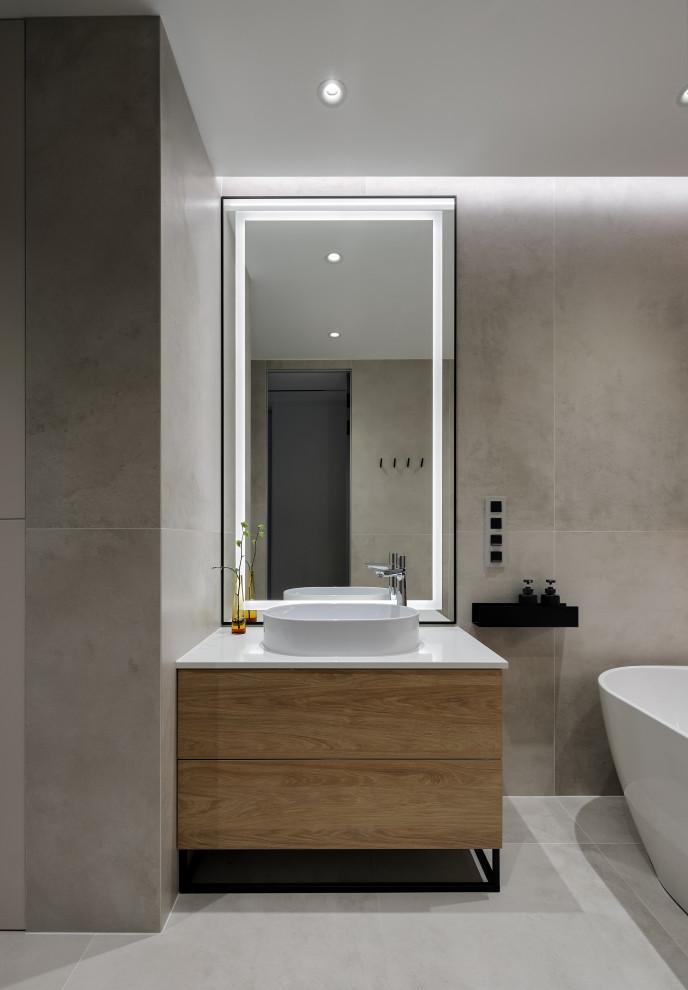 Medium sized contemporary ensuite bathroom in Saint Petersburg with flat-panel cabinets, light wood cabinets, a freestanding bath, a wall mounted toilet, beige tiles, porcelain tiles, beige walls, porcelain flooring, a built-in sink, solid surface worktops, grey floors, white worktops, a single sink, a freestanding vanity unit and a drop ceiling.