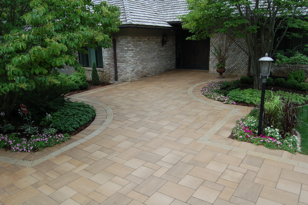 Design ideas for a large modern front yard full sun driveway in Minneapolis with concrete pavers.