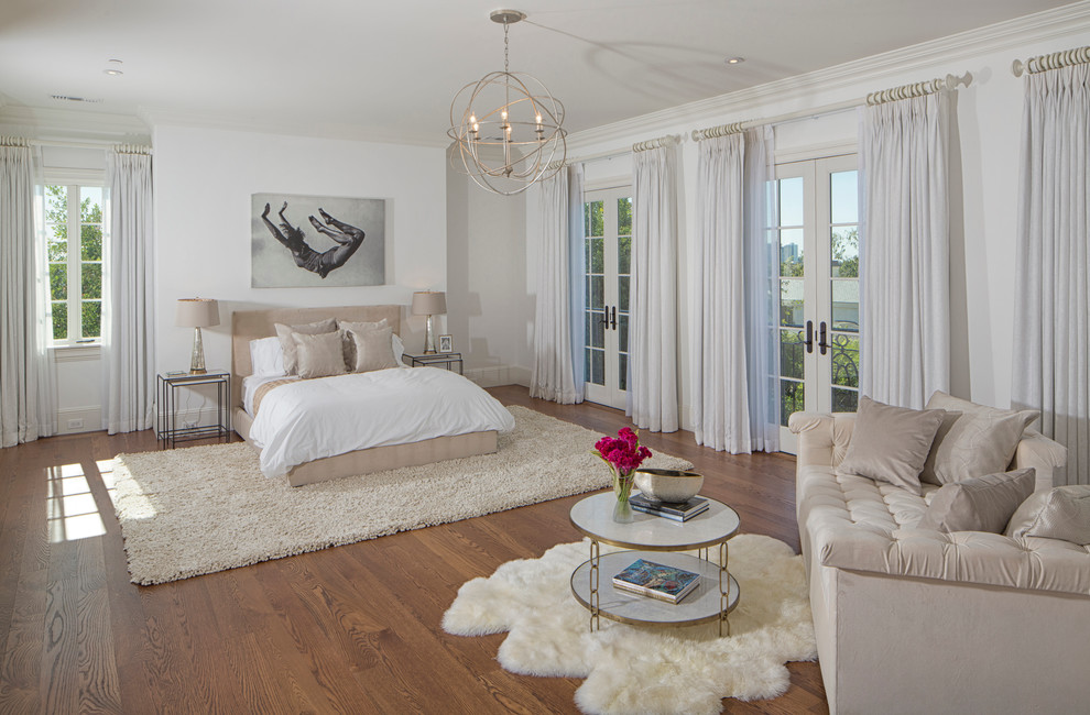 This is an example of a transitional bedroom in Los Angeles with white walls and medium hardwood floors.