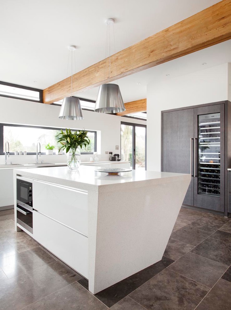 Design ideas for a large contemporary open plan kitchen in Other with an undermount sink, flat-panel cabinets, grey cabinets, quartzite benchtops, white splashback, glass sheet splashback, stainless steel appliances, ceramic floors and with island.