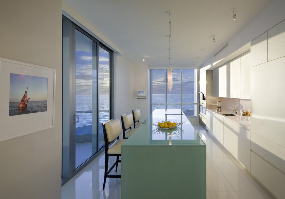Photo of a modern kitchen in Miami with panelled appliances and white floor.