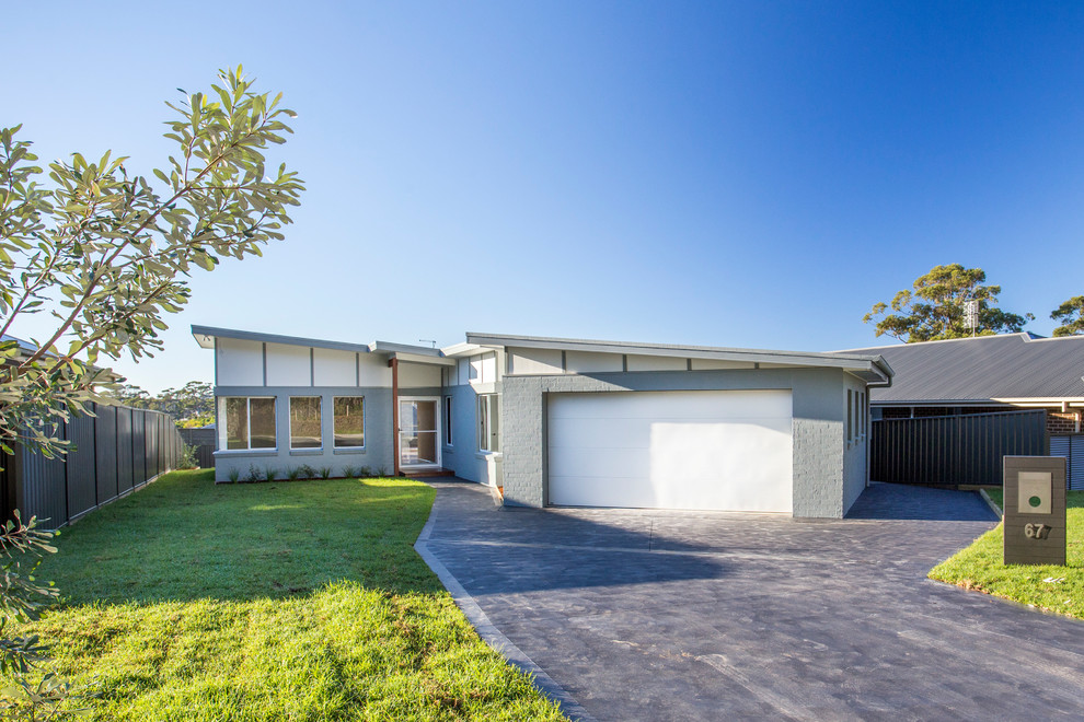 Design ideas for a large contemporary one-storey brick grey house exterior in Wollongong with a flat roof and a metal roof.