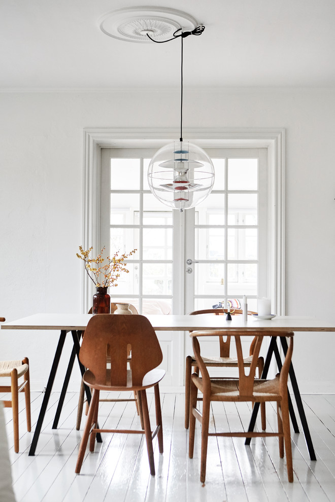Photo of a mid-sized scandinavian separate dining room in Aarhus with white walls, painted wood floors, no fireplace and white floor.